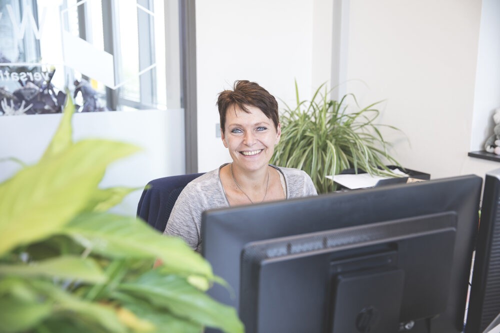 Vrouw lachend aan bureau